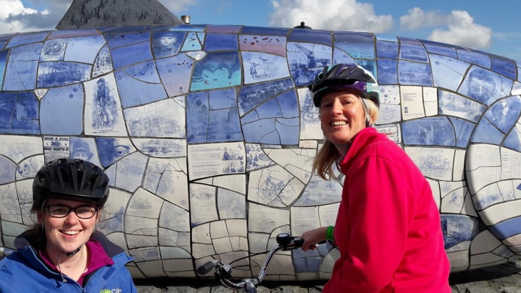 Two people from LORAG’s Wheely Inclusive Cycling Project stopping at The Big Fish on a Walk Wheel Cycle Trust led ride