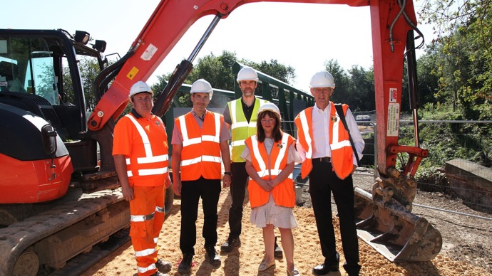 Councillors visit the project on Castleford Greenway and stand in front of a digger used in the construction