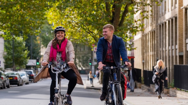A man And A Woman Cycle On A London Road 