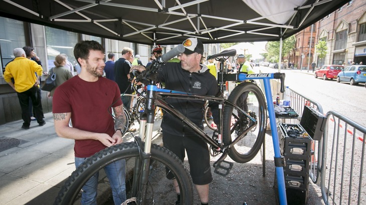 A man helps someone fix their bike at a bike maintenance workshop in belfast