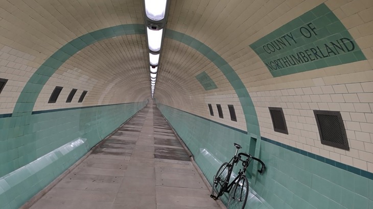 A bike rests against the blue and white tiled walls of the Tyne River foot tunnel 
