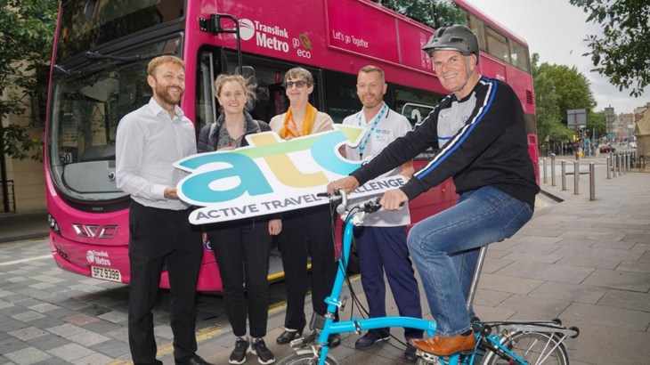 People celebrating the Active Travel Challenge in front of a bus in Belfast