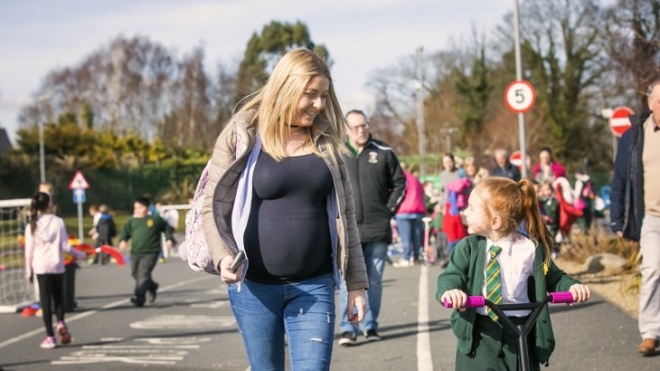 A mother walks with her daughter to school 