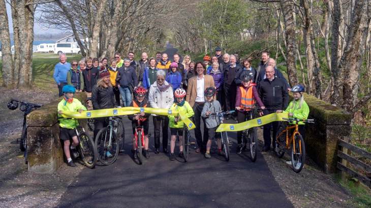 Group of people cutting the ribbon at opening of new walking and cycling path