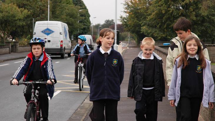 Children in school uniform walking and cycling 