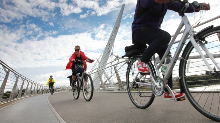 People on bikes on a cycling and walking bridge