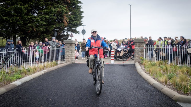 Elderly Male Cyclist With Crowd In Background