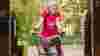 Lady smiling as she rides her trike through an archway