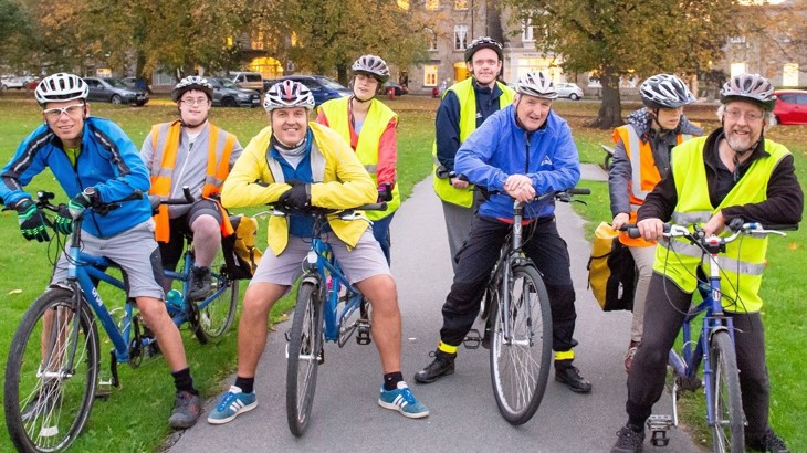 group of cyclists in high vis vests in park