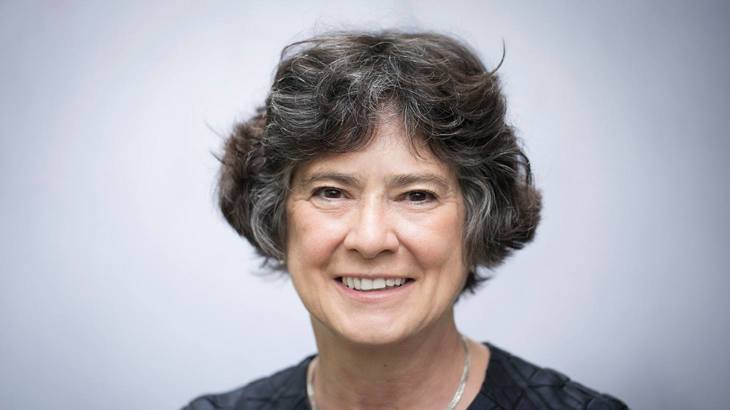 Head shot of Walk Wheel Cycle Trust Chair of Trustees, Lynne Berry, wearing a dark grey top in front of a pale grey background.