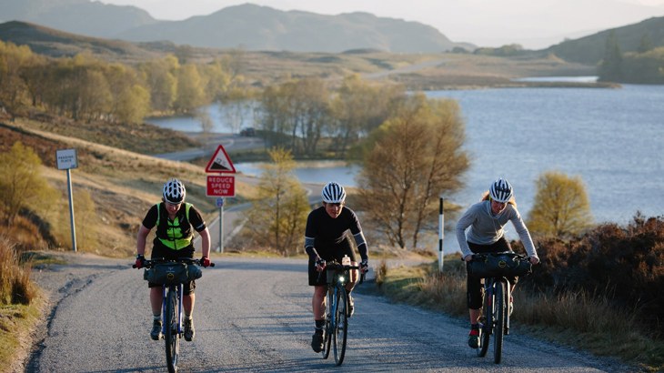 Three cycle tourers cycling along the Caledonia Way in Scotland