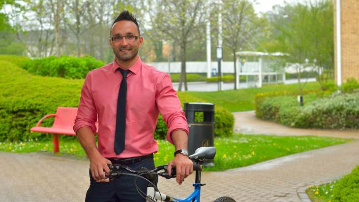 man in shirt and tie with his bike outside office building